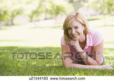 Woman relaxing outdoors smiling View Large Photo Image Stock Image - Woman relaxing outdoors smiling. Fotosearch
