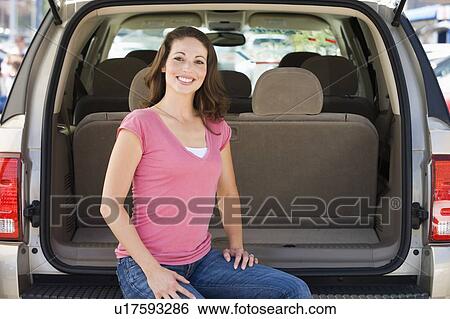 Woman sitting in back of van smiling View Large Photo Image Stock Photograph - Woman sitting in back of van smiling. Fotosearch