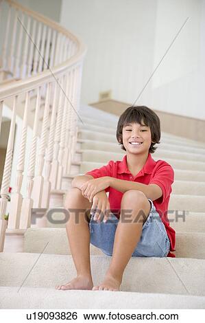 Stock Photograph - Young Boy Sitting On A Stairwell At Home. Fotosearch