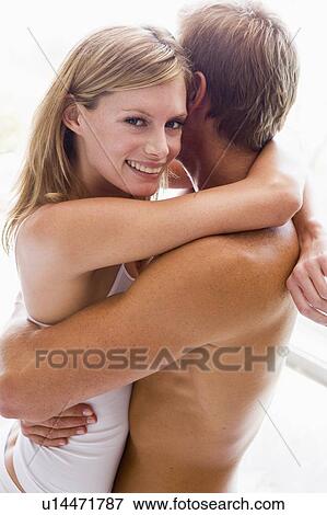 Couple embracing in bedroom smiling View Large Photo Image Stock Photo - Couple embracing in bedroom smiling. Fotosearch