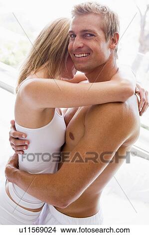 Couple in bedroom embracing and smiling View Large Photo Image Picture - Couple in bedroom embracing and smiling. Fotosearch