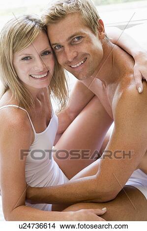 Couple in bedroom embracing and smiling View Large Photo Image Picture - Couple in bedroom embracing and smiling. Fotosearch