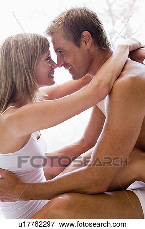 Couple in bedroom embracing and smiling View Large Photo Image Stock Photo - Couple in bedroom embracing and smiling. Fotosearch