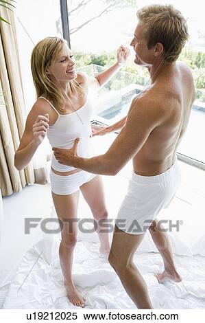 Couple in bedroom jumping on bed and smiling View Large Photo Image Stock Photography - Couple in bedroom jumping on bed and smiling. Fotosearch