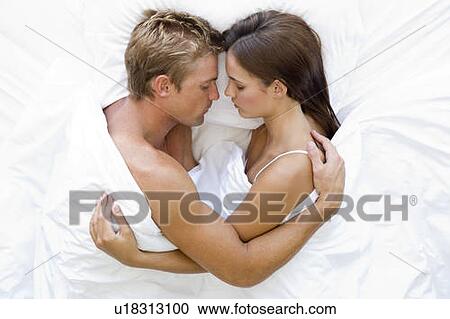 Stock Image - Couple lying in bed sleeping. Fotosearch