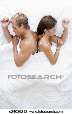 Couple lying in bed sleeping View Large Photo Image Stock Image - Couple lying in bed sleeping. Fotosearch