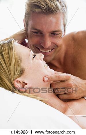 Couple lying in bed smiling View Large Photo Image Stock Image - Couple lying in bed smiling. Fotosearch