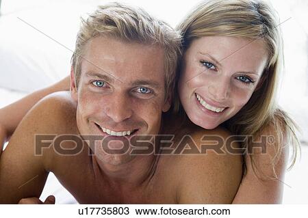 Couple lying in bed smiling View Large Photo Image Stock Image - Couple lying in bed smiling. Fotosearch