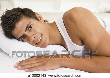 Man lying in bed smiling View Large Photo Image Stock Image - Man lying in bed smiling. Fotosearch