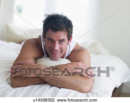 Man lying in bed smiling View Large Photo Image Stock Image - Man lying in bed smiling. Fotosearch
