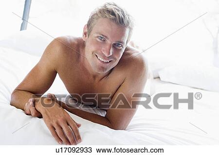 Man lying in bed smiling View Large Photo Image Stock Image - Man lying in bed smiling. Fotosearch