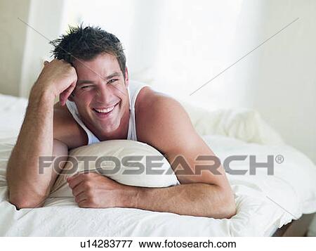 Man lying in bed smiling View Large Photo Image Stock Photo - Man lying in bed smiling. Fotosearch