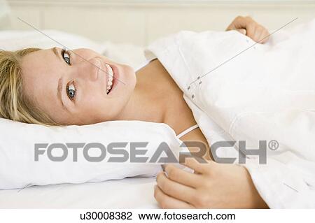 Woman lying in bed smiling View Large Photo Image Stock Image - Woman lying in bed smiling. Fotosearch
