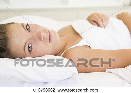 Woman lying in bed View Large Photo Image Stock Image - Woman lying in bed. Fotosearch