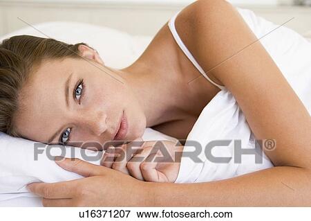 Woman lying in bed View Large Photo Image Stock Photo - Woman lying in bed. Fotosearch