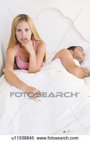 Stock Photography - Young couple in bed having trouble sleeping. Fotosearch