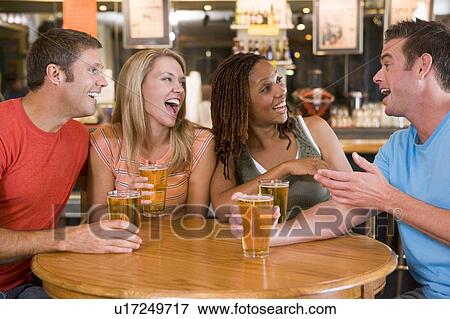 Stock Photo - Two couples having beer together. Fotosearch