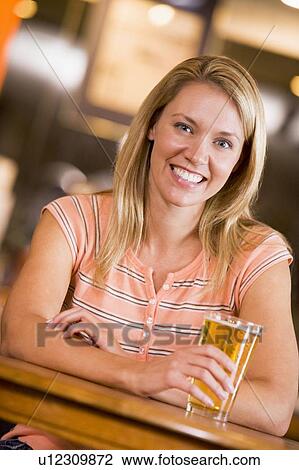 Stock Image - Woman having a glass of beer. Fotosearch