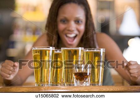 Stock Image - Woman posing with several beer glasses. Fotosearch