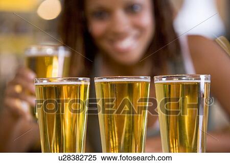 Stock Photography - Woman posing with several beer glasses. Fotosearch