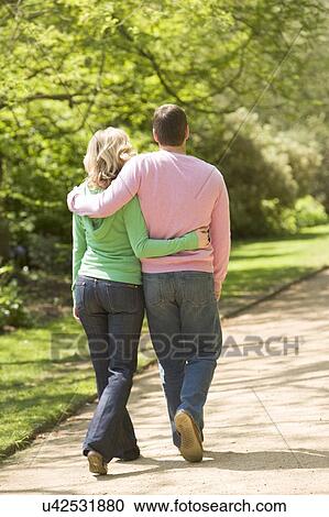 Stock Image - Couple walking on path arm in arm. Fotosearch