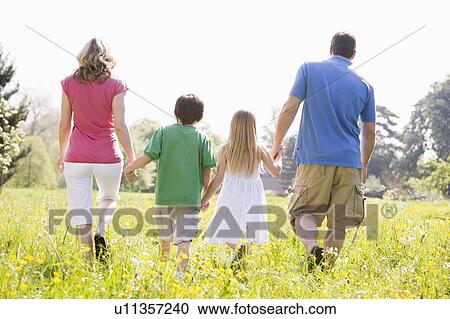Stock Image - Family walking outdoors holding hands. Fotosearch
