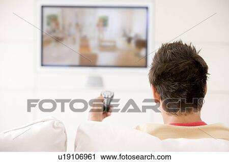 Man in living room watching television View Large Photo Image Stock Image - Man in living room watching television. Fotosearch