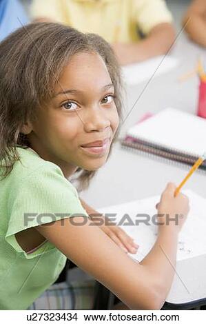 Picture - Student in class writing (selective focus). Fotosearch