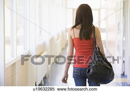 Stock Photography - Student standing in corridor (high key). Fotosearch