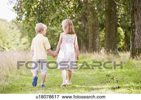 Two young children walking on path holding hands View Large Photo Image Stock Photo - Two young children walking on path holding hands. Fotosearch