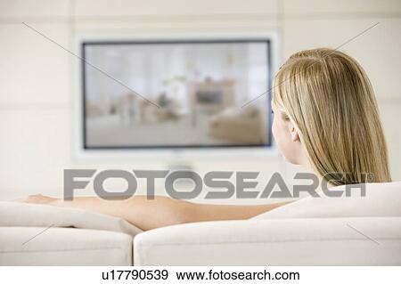 Woman in living room watching television View Large Photo Image Stock Photo - Woman in living room watching television. Fotosearch