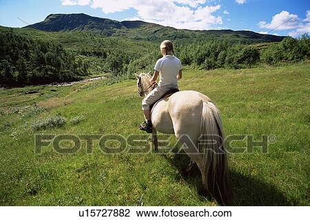 Woman outdoors riding horse in scenic location View Large Photo Image Stock Image - Woman outdoors riding horse in scenic location. Fotosearch