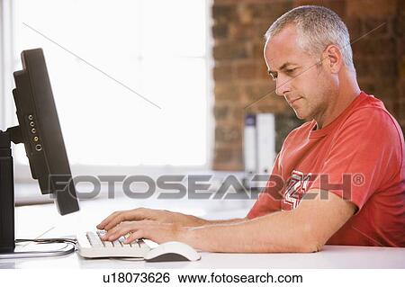 Stock Photograph - Businessman in office typing on computer. Fotosearch