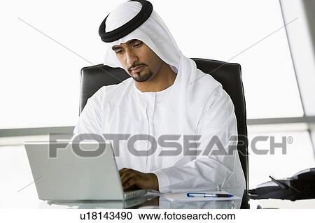 Businessman in office with laptop working (high key/selective focus) View Large Photo Image Stock Image - Businessman in office with laptop working (high key/selective focus). Fotosearch