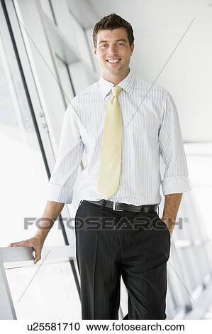 Businessman standing in corridor smiling View Large Photo Image Stock Image - Businessman standing in corridor smiling. Fotosearch