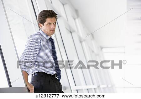 Stock Photo - Businessman standing in corridor. Fotosearch