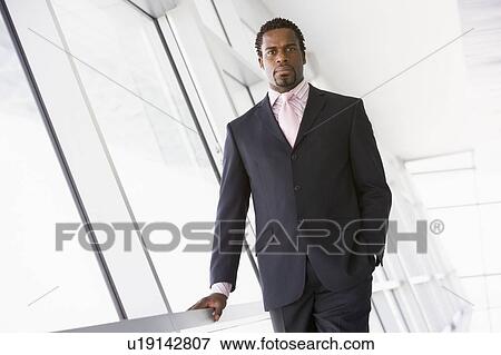 Stock Photo - Businessman standing in corridor. Fotosearch