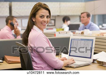 Businesswoman in cubicle smiling View Large Photo Image Stock Image - Businesswoman in cubicle smiling. Fotosearch