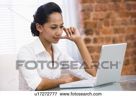 Businesswoman in office with laptop View Large Photo Image Stock Photo - Businesswoman in office with laptop. Fotosearch