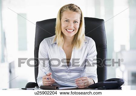 Businesswoman in office with personal organizer smiling View Large Photo Image Picture - Businesswoman in office with personal organizer smiling. Fotosearch