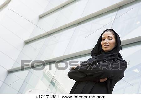 Stock Image - Businesswoman standing outdoors by building (selective focus). Fotosearch
