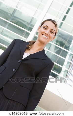 Businesswoman standing outdoors smiling View Large Photo Image Stock Photograph - Businesswoman standing outdoors smiling. Fotosearch
