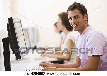 Three people sitting in computer room typing and smiling View Large Photo Image Stock Image - Three people sitting in computer room typing and smiling. Fotosearch