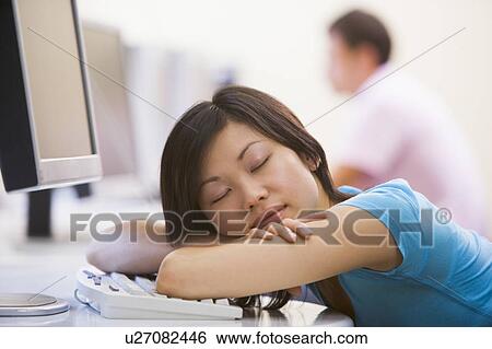 Stock Photograph - Woman in computer room sleeping. Fotosearch