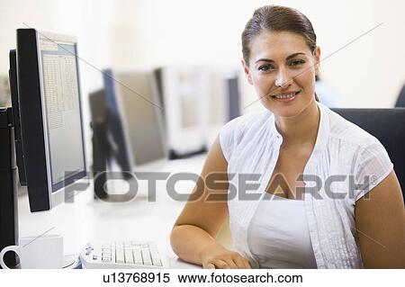 Woman sitting in computer room smiling View Large Photo Image Stock Photography - Woman sitting in computer room smiling. Fotosearch