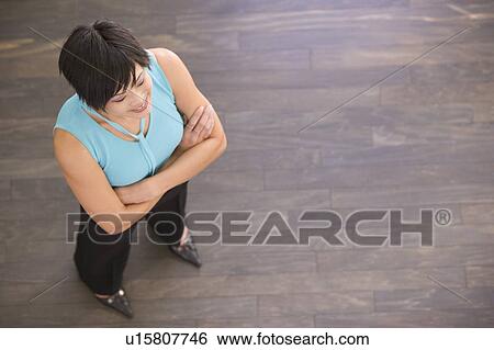 Stock Photograph - Businesswoman standing indoors smiling. Fotosearch