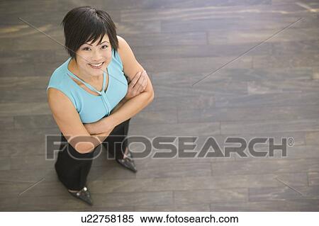 Businesswoman standing indoors smiling View Large Photo Image Stock Photography - Businesswoman standing indoors smiling. Fotosearch