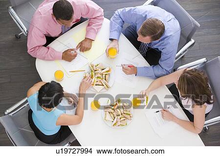 Four businesspeople at boardroom table with sandwiches View Large Photo Image Picture - Four businesspeople at boardroom table with sandwiches. Fotosearch