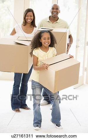 Stock Image - Family moving into new home smiling. Fotosearch