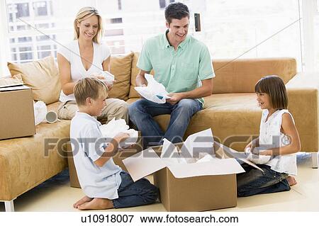 Family unpacking boxes in new home smiling View Large Photo Image Stock Photo - Family unpacking boxes in new home smiling. Fotosearch